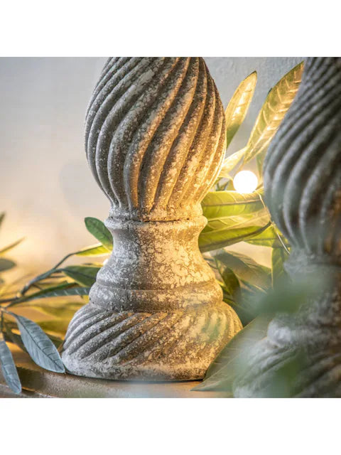 A rustic, grey candlestick holder featuring a distressed finish