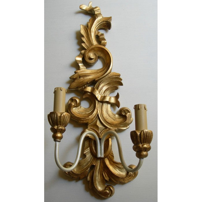 Ornate gold baroque wall sconce with a dual candle light fixture.