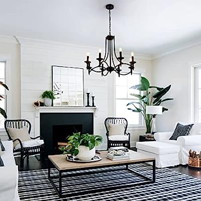 Elegant black wrought iron candelabra chandelier with six glowing bulb lights hanging from a chain against