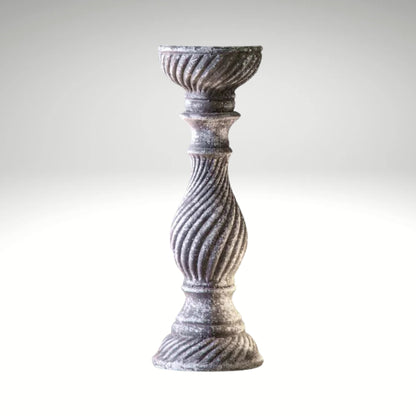A rustic, grey candlestick holder featuring a distressed finish