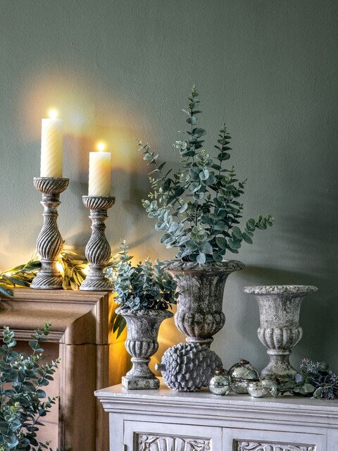 A rustic, grey candlestick holder featuring a distressed finish