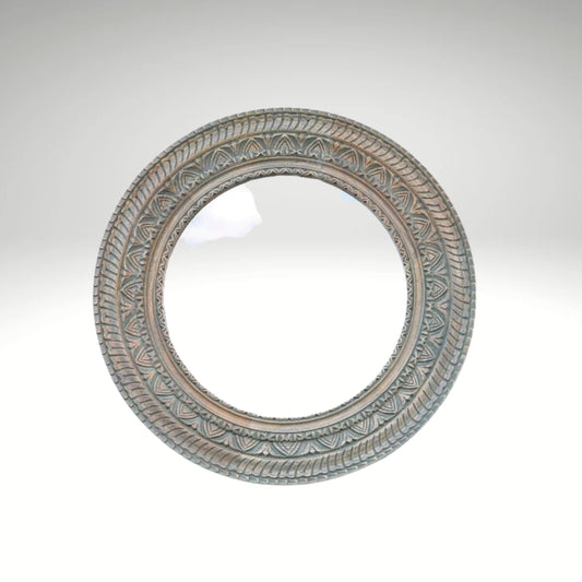 Rustic round wall mirror with an intricately carved ornate border.