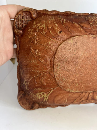 A rectangular brown wooden tray featuring a detailed, high-relief hand-carved floral arrangement of roses and bluebells in the center with a decorative wavy border.