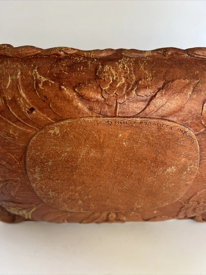 A rectangular brown wooden tray featuring a detailed, high-relief hand-carved floral arrangement of roses and bluebells in the center with a decorative wavy border.