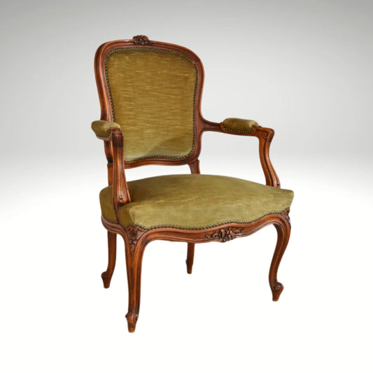 An antique French-style wooden accent chair featuring moss green velvet cushions and curved cabriole legs.