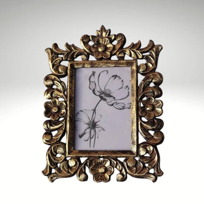 A rectangular photo frame with an ornate, hand-carved antique gold border