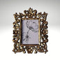 A rectangular photo frame with an ornate, hand-carved antique gold border