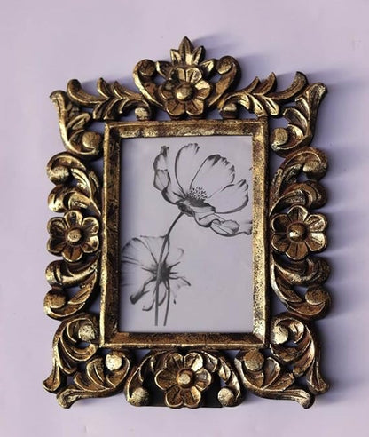 A rectangular photo frame with an ornate, hand-carved antique gold border