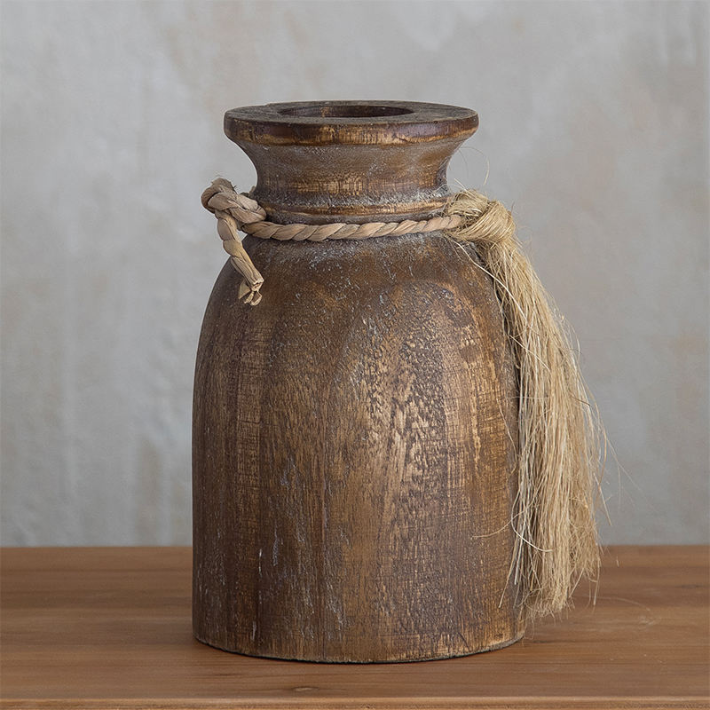 A pair of rustic brown wooden vases in different sizes, each decorated with a jute rope tassel tied around the neck.