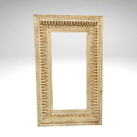 An ornate, rectangular white-washed wooden mirror frame