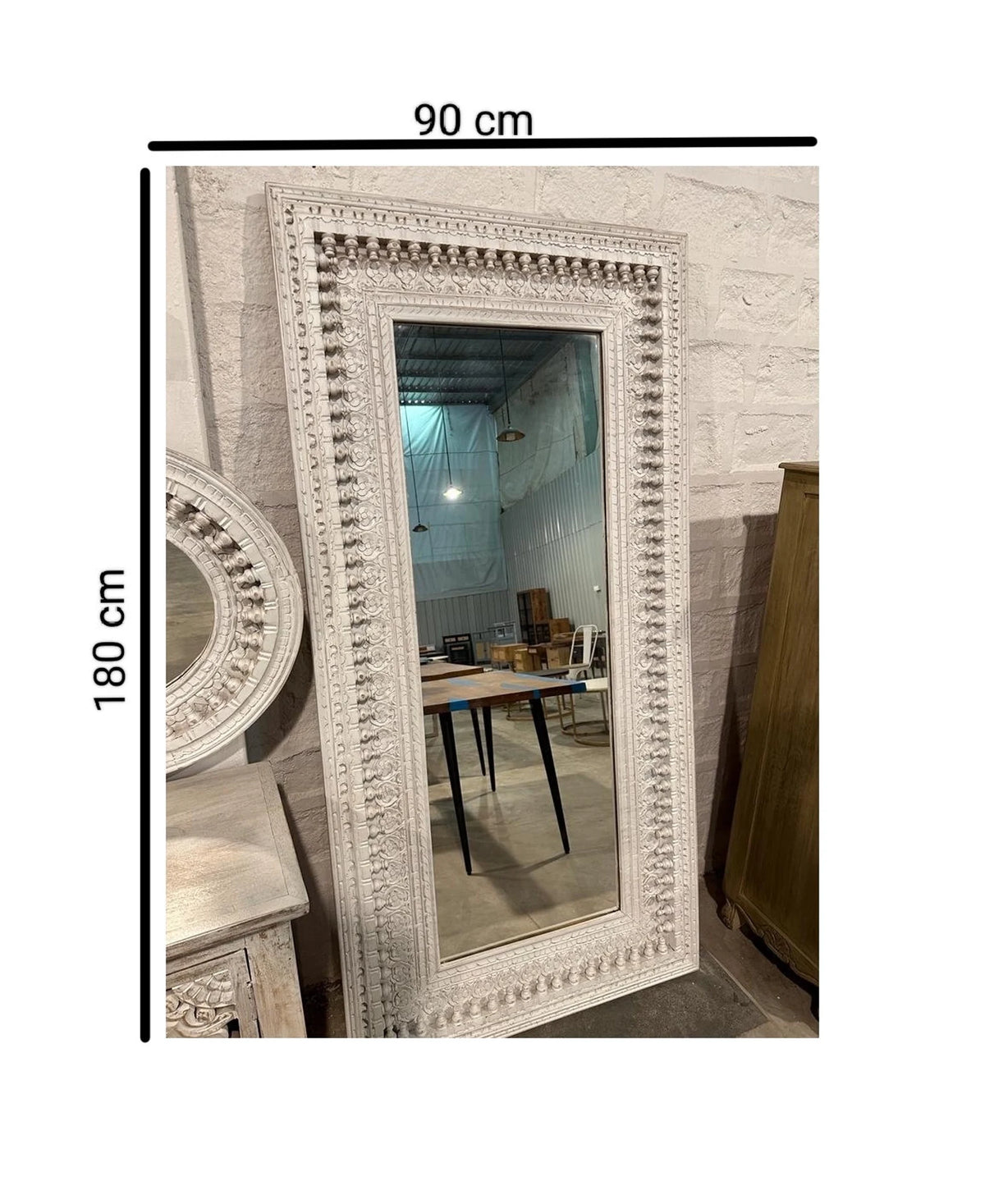 An ornate, rectangular white-washed wooden mirror frame