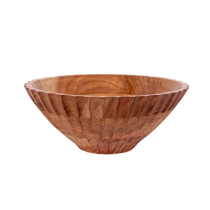 A large, fluted wooden serving bowl with a carved exterior pattern sitting on a concrete countertop.