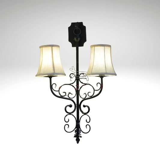 Antique-style black metal double wall lamp featuring elegant scrolls and glowing filament bulbs.