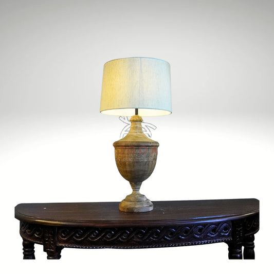 A rustic table lamp featuring a turned wooden urn-shaped base with a natural grain finish