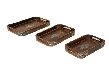 A stack of three rectangular dark brown wooden serving trays featuring ornate metal diamond inlays in the center and decorative metal borders along the corners.