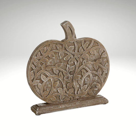 A decorative wooden pumpkin cutout featuring an intricate carved vine and leaf pattern on a stable rectangular base.