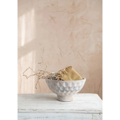 A round, natural mango wood bowl with a footed base and a carved, circular pattern decorating the outer surface.