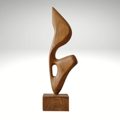 An abstract biomorphic wood sculpture with smooth curves and a hollow cutout, mounted on a square wooden base.