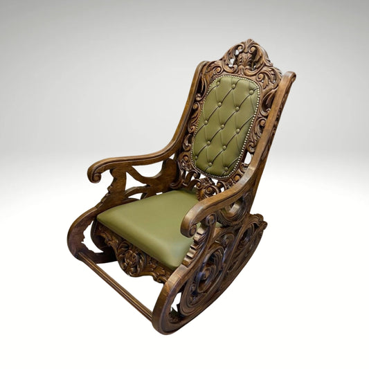 Vintage-style wooden rocking chair with intricate carvings and green cushioned upholstery.