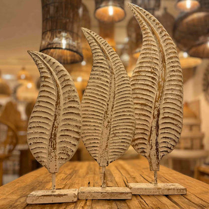  Distressed white metal leaf statue with rustic brown accents mounted on a stand.