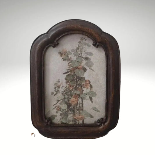 A vintage arched dark wood picture frame