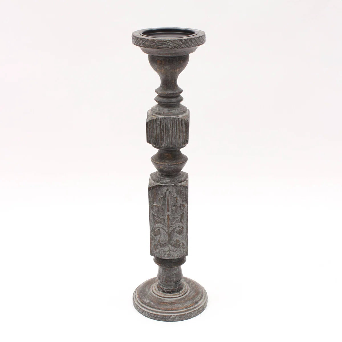 A pair of tall, hand-carved wooden pillar candle holders with a distressed black finish