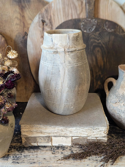 A vintage barrel-shaped carved wooden vessel 