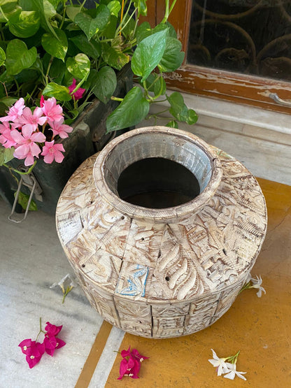 A short, wide ceramic vase featuring textured, block-stamped relief patterns in off-white and beige earthy tones.