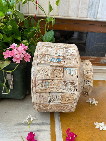 A short, wide ceramic vase featuring textured, block-stamped relief patterns in off-white and beige earthy tones.