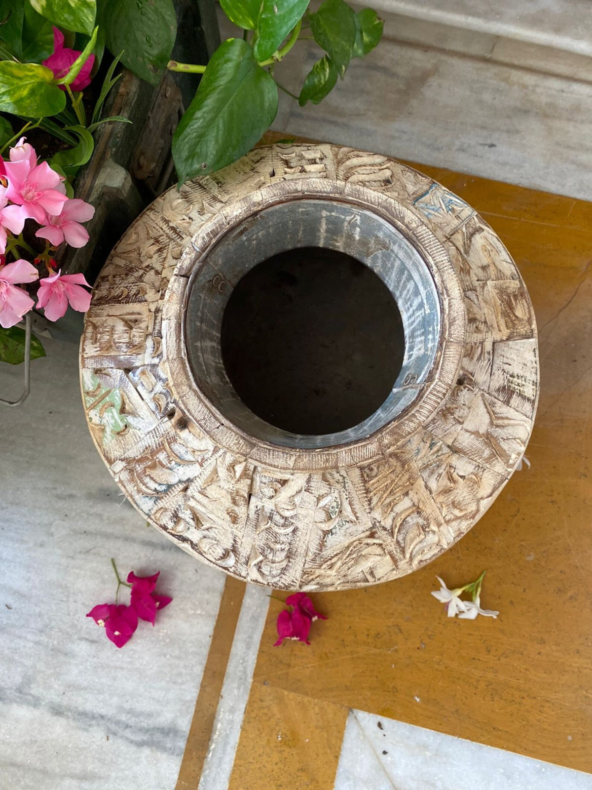 A short, wide ceramic vase featuring textured, block-stamped relief patterns in off-white and beige earthy tones.