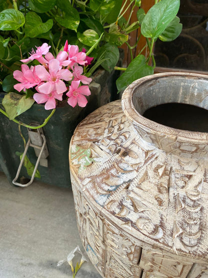 A short, wide ceramic vase featuring textured, block-stamped relief patterns in off-white and beige earthy tones.