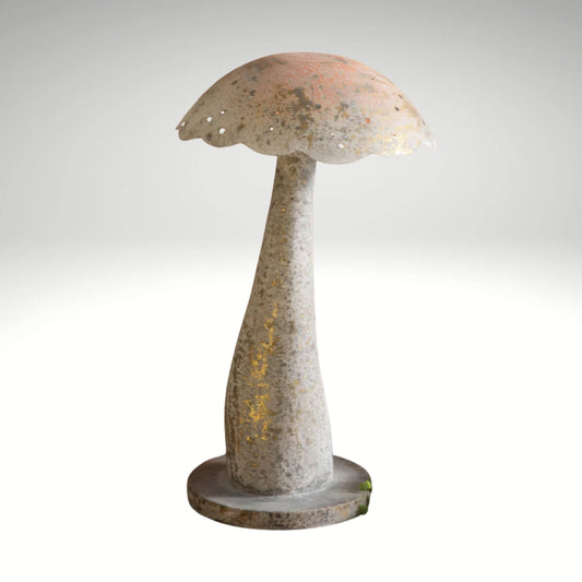 A rustic, mushroom-shaped decorative piece with a textured light-colored finish and golden highlights, placed on a wooden table alongside potted