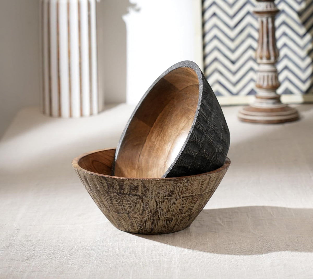 A round wooden bowl with a natural light brown wood interior and a textured, dark charcoal-grey ribbed exterior.