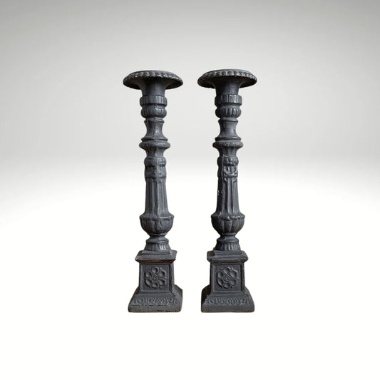 A pair of vintage, ornate dark grey wooden candle holders.