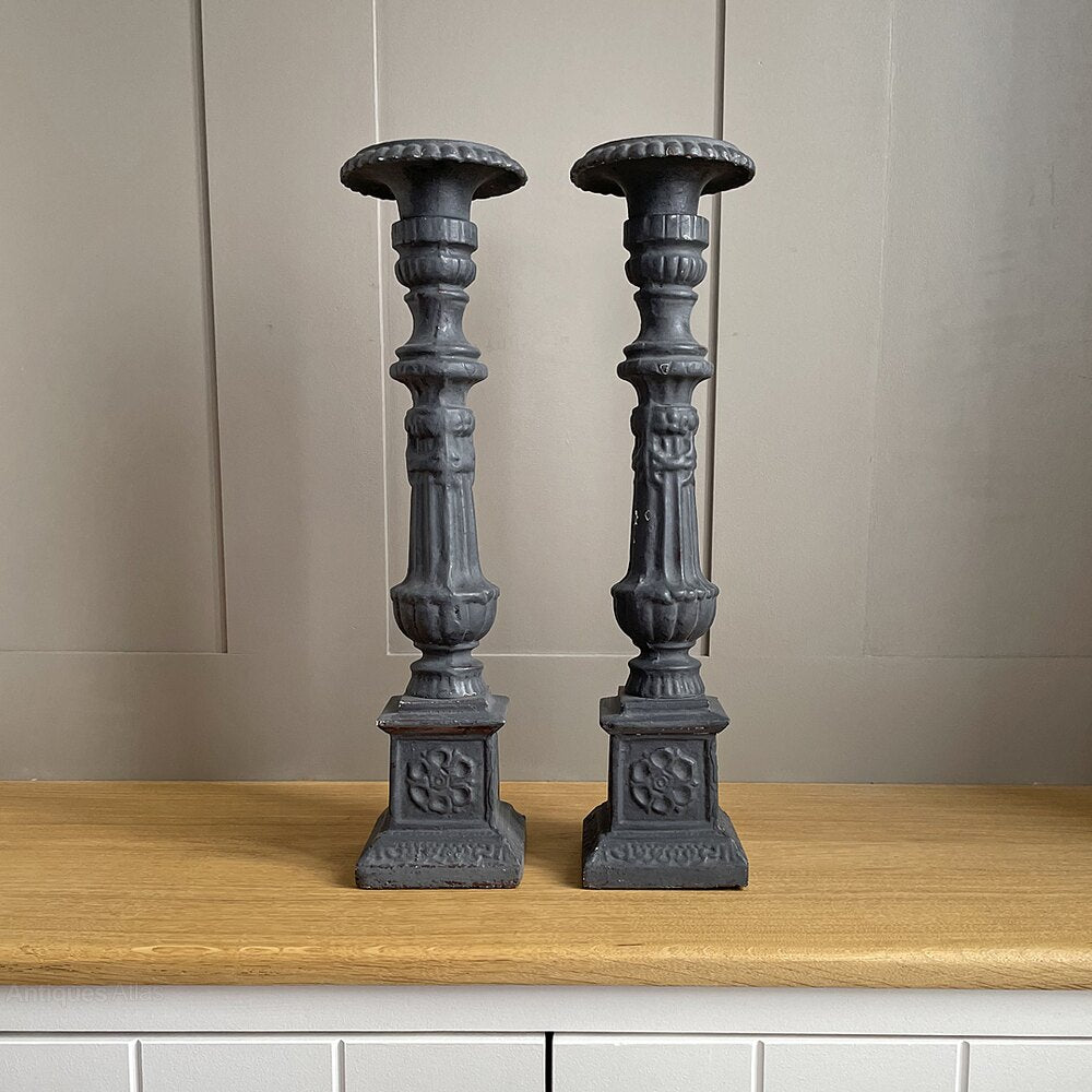 A pair of vintage, ornate dark grey wooden candle holders