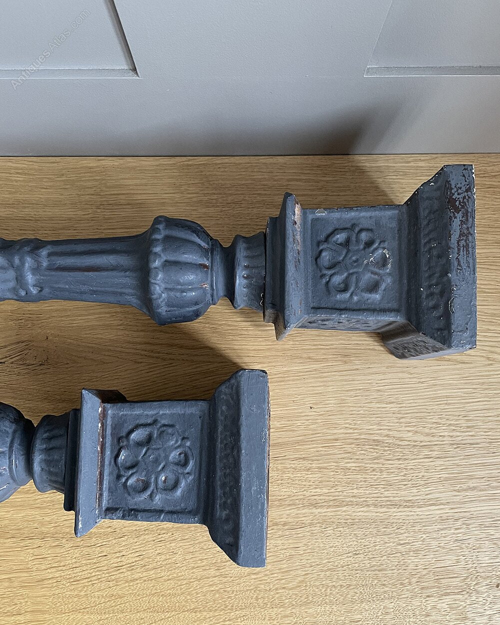 A pair of vintage, ornate dark grey wooden candle holders.