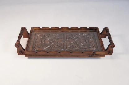 A rectangular wooden serving tray with detailed floral carvings on both handles and a smooth natural grain finish.