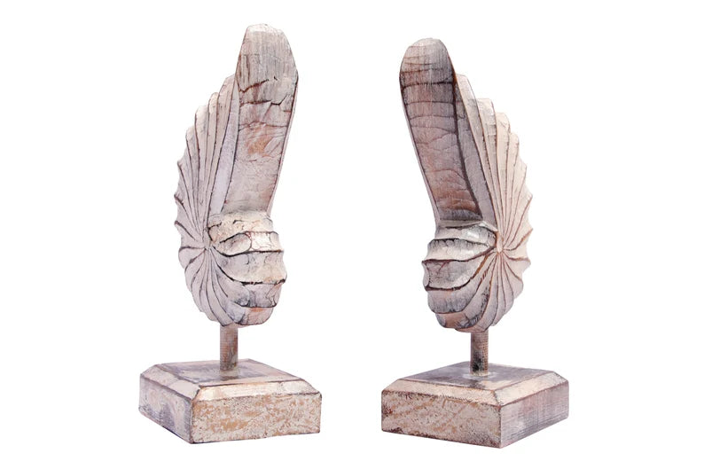 A hand-carved wooden nautilus shell sculpture with a distressed white finish.