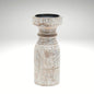 A rustic whitewashed wooden pillar candle holder with a distressed finish