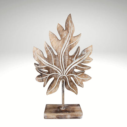 Carved wooden tropical leaf sculpture on a stand.