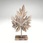 Carved wooden tropical leaf sculpture on a stand.