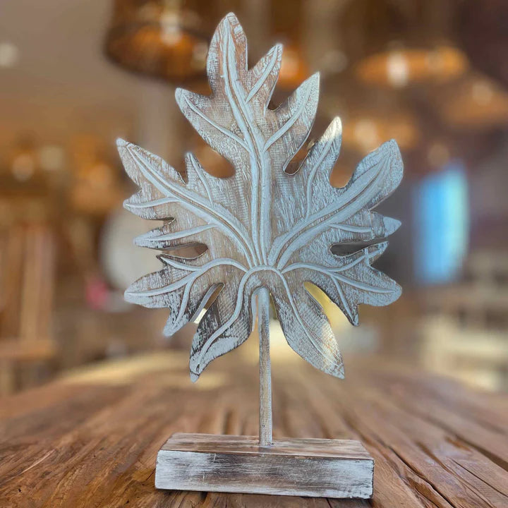 Anticoarte - Decorative leaf sculpture on a wooden stand with a blurred background