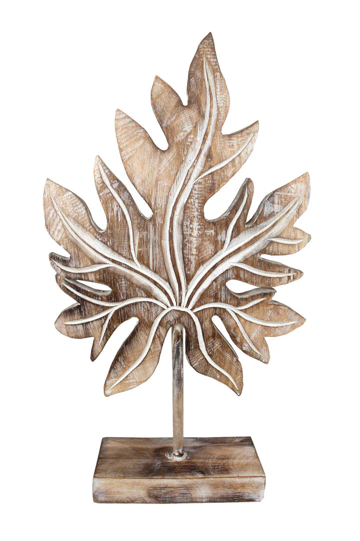 Carved wooden tropical leaf sculpture on a stand.
