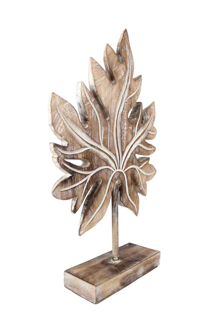 Carved wooden tropical leaf sculpture on a stand.