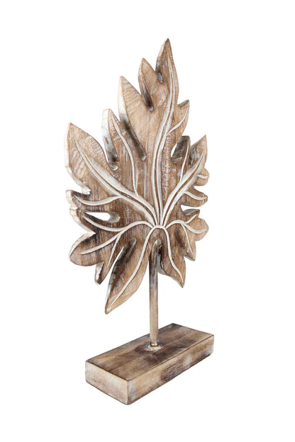 Carved wooden tropical leaf sculpture on a stand.