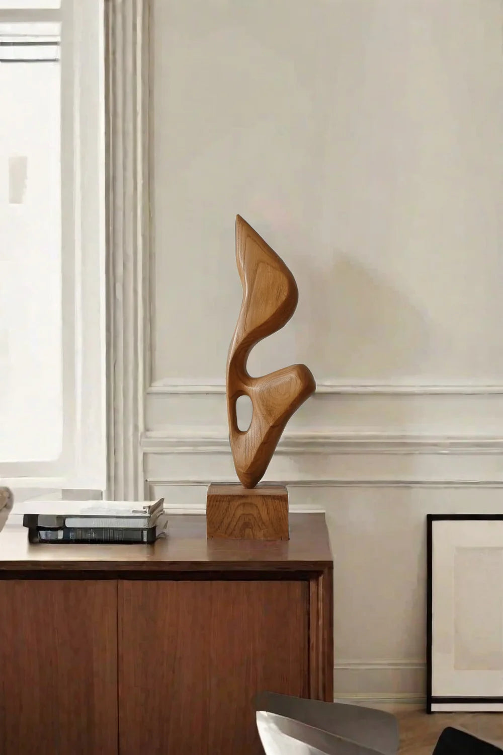 Anticoarte - Wooden abstract sculpture on a wooden cabinet in a room with a window and framed picture.