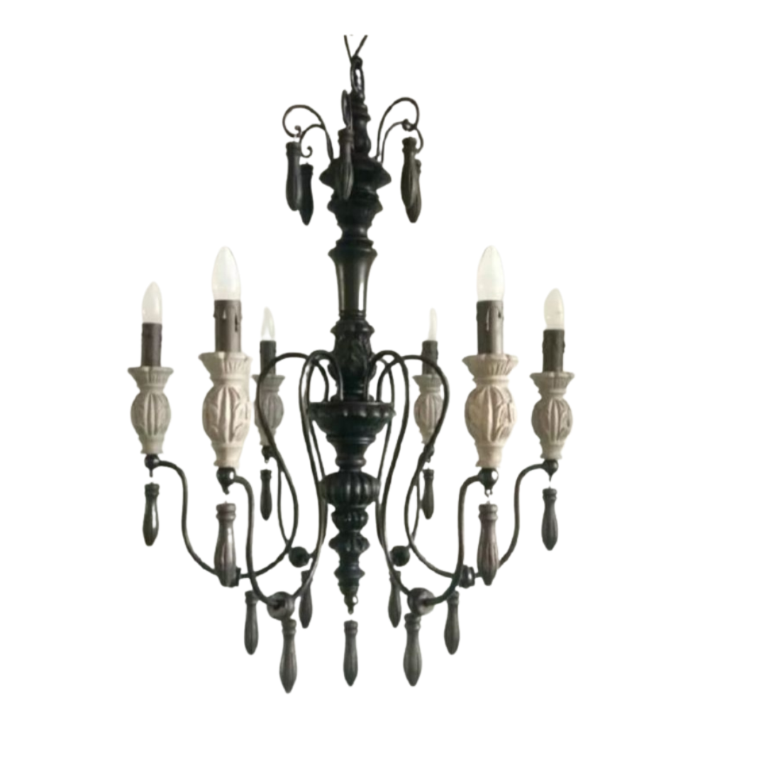 Rustic gothic-inspired wrought iron chandelier featuring carved details and flame-tip lights.