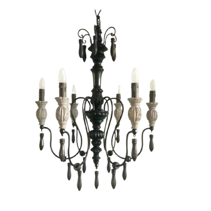 Rustic gothic-inspired wrought iron chandelier featuring carved details and flame-tip lights.
