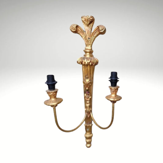 Ornate vintage brass wall lamp with two arms and a detailed gold finish