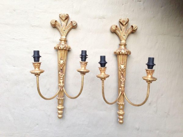 Ornate vintage brass wall lamp with two arms and a detailed gold finish